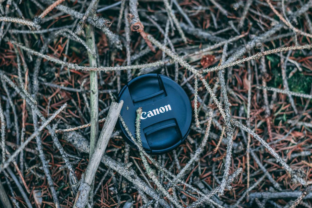 Close-up of a compact camera cleaning kit including brushes, solution bottle, and cloths.