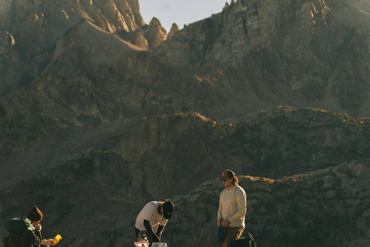 A hiker struggling under the weight of a heavy DSLR on their neck during a trail.