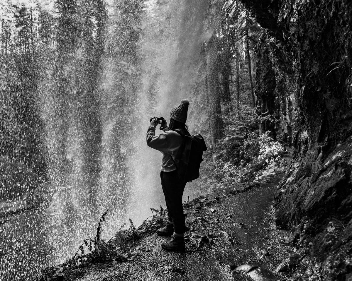 Hiker holding an adventure sports camera during sunset