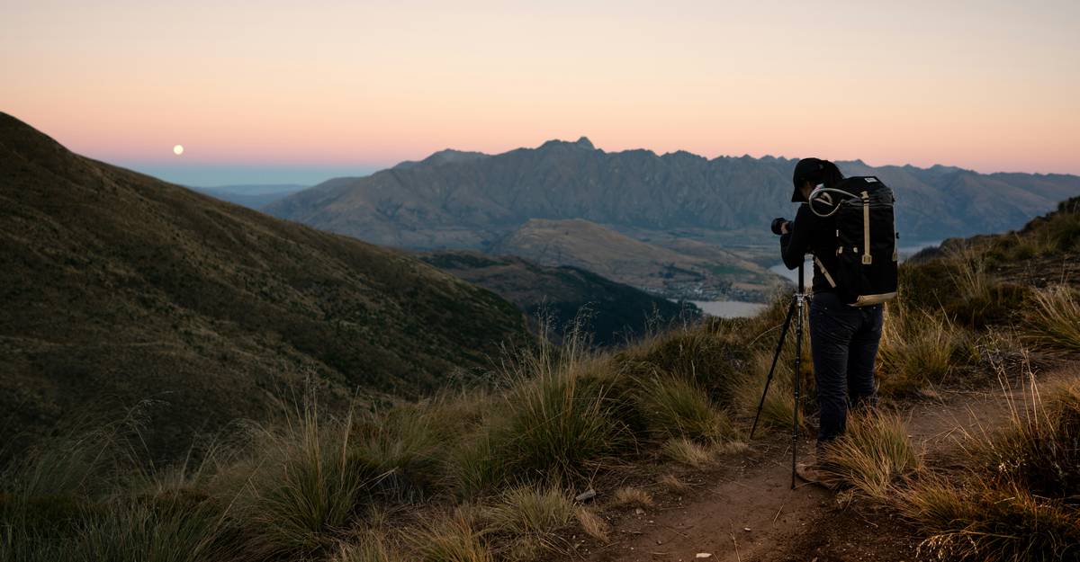 A rugged adventure camera waterproof being used by a hiker near a waterfall.