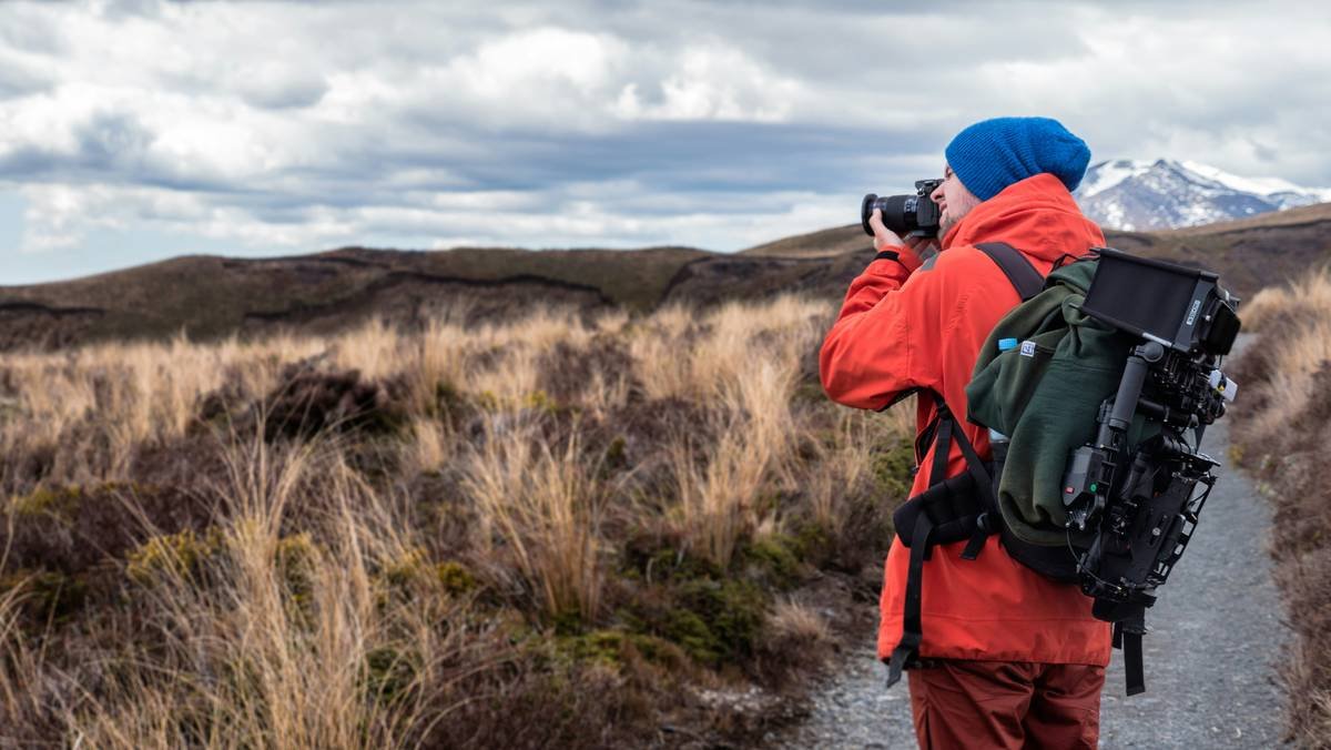 Bar chart comparing battery life, waterproof rating, and weight of top 5 adventure video cameras for hiking